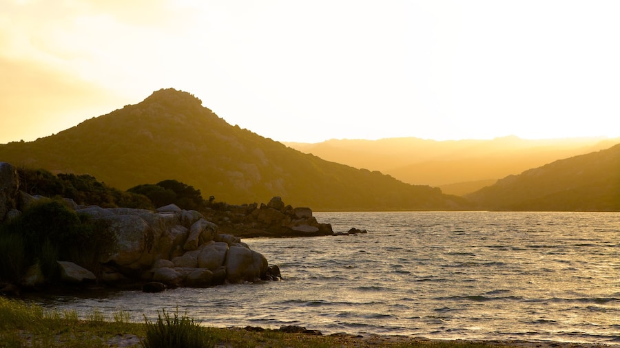 Plage de Balistra que inclui um pĂŽr do sol e litoral rochoso