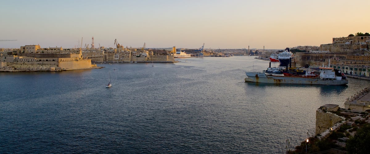Grand Harbour showing a bay or harbor, a coastal town and a sunset