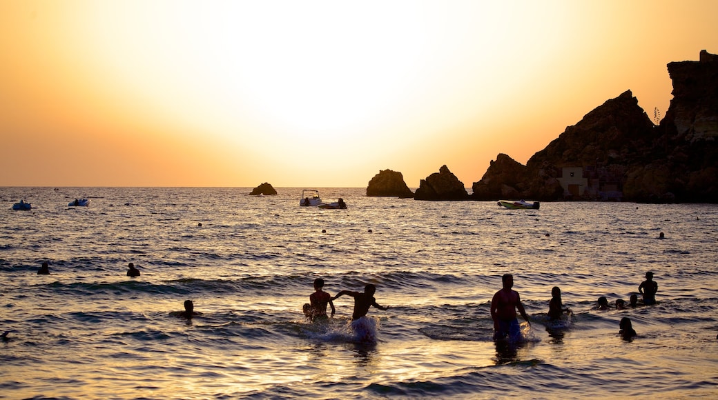 Playa de arena dorada ofreciendo un atardecer, vistas de una costa y natación