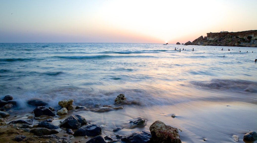 Plage Golden Sands montrant coucher de soleil et côte rocheuse