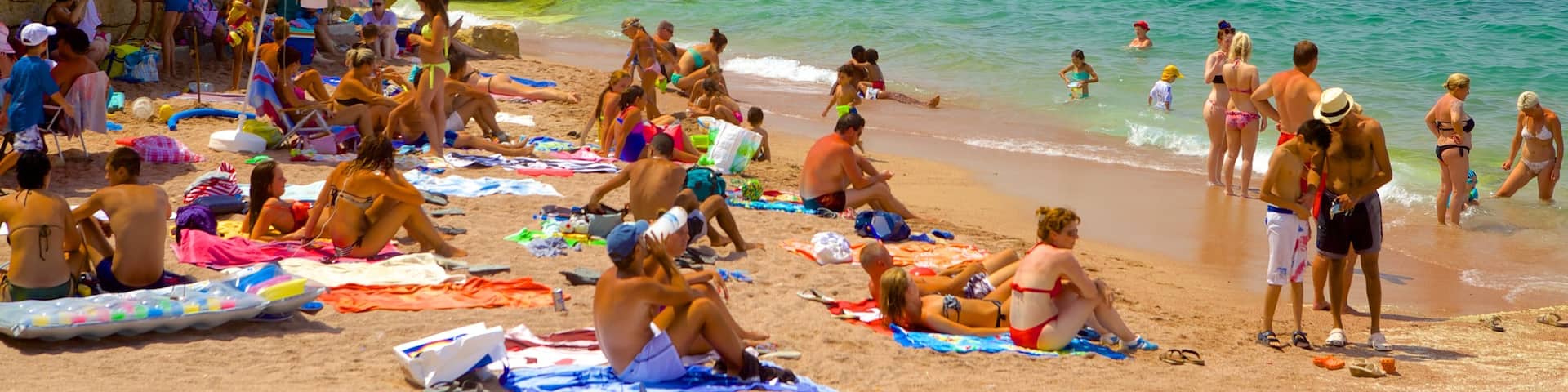 Bugibba Beach featuring a sandy beach as well as a large group of people