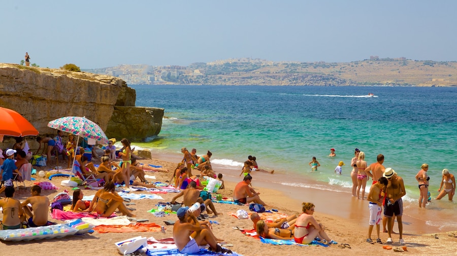 Playa Bugibba mostrando una playa de arena y también un grupo grande de personas