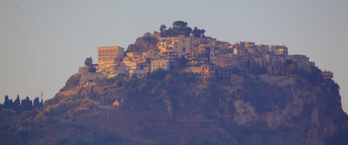 Giardini Naxos montrant petite ville ou village et montagnes