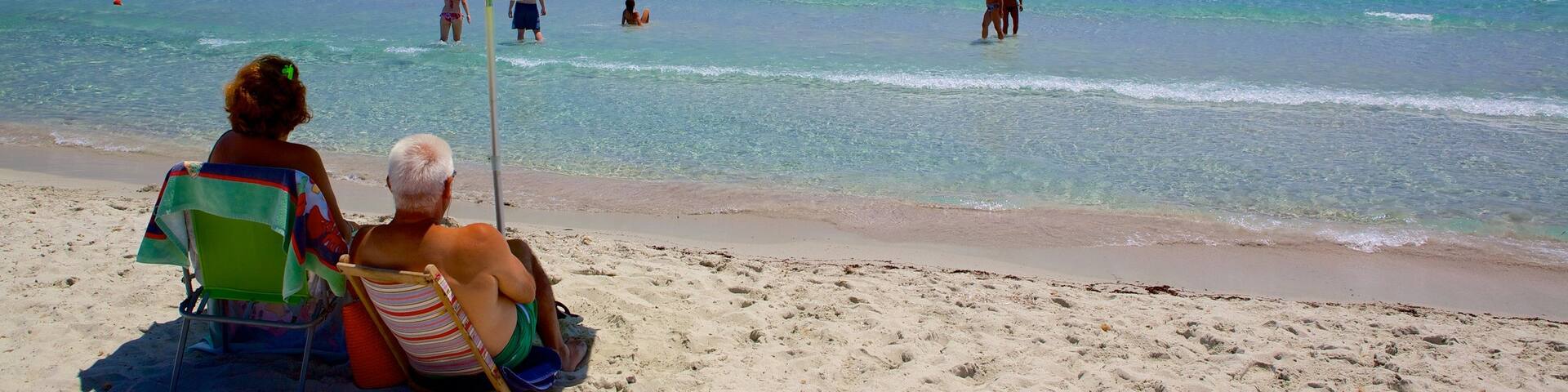 Simius Beach showing swimming and a sandy beach as well as a couple