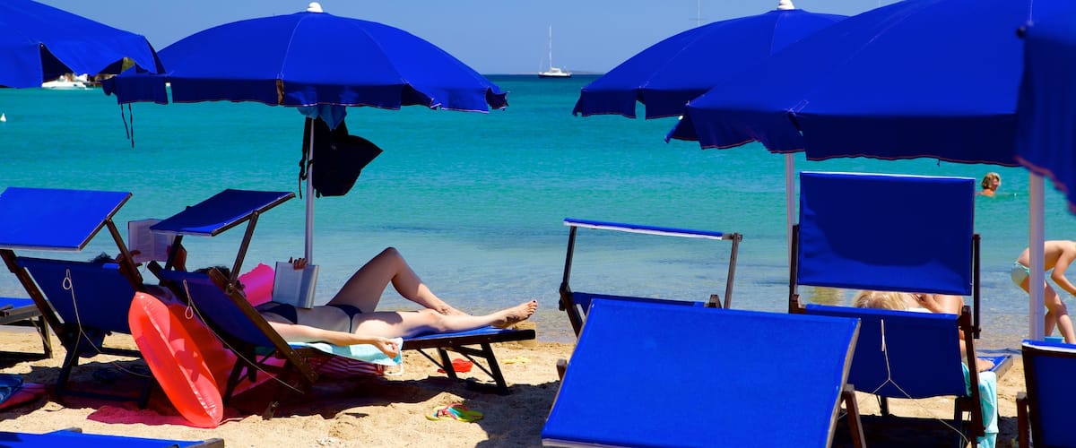 Le Saline Beach showing a luxury hotel or resort and a sandy beach as well as an individual female