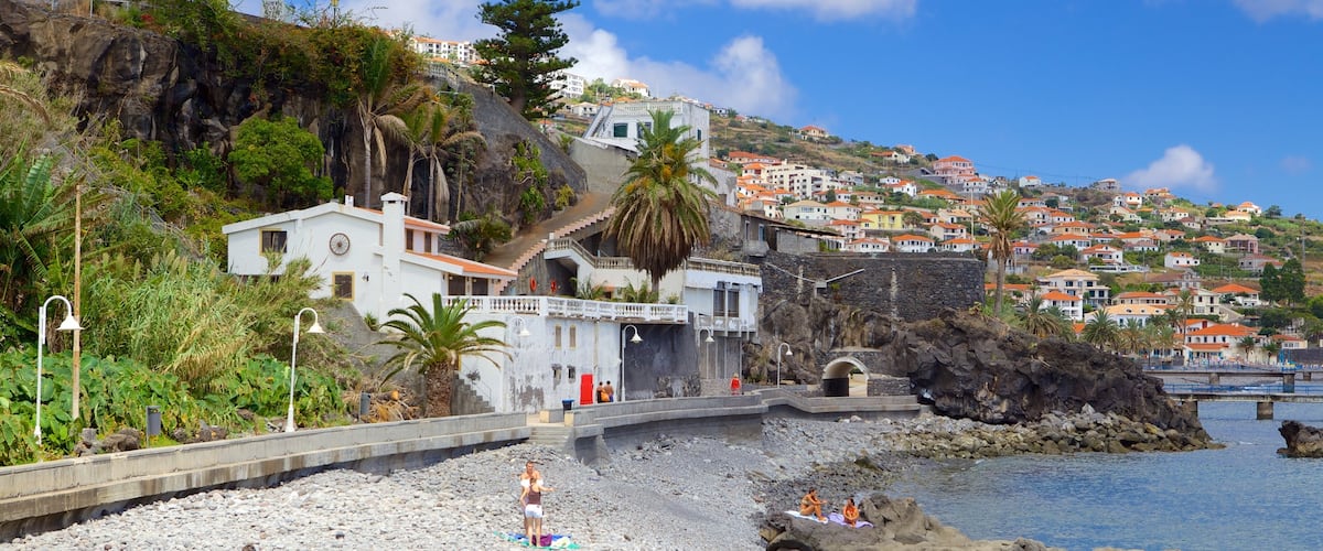 Playa de Santa Cruz que incluye una ciudad costera y una playa de guijarros y también un pequeño grupo de personas
