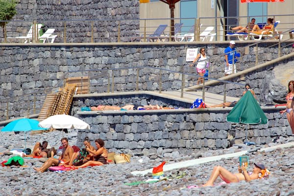 Plage de Reis Magos qui includes plage de galets aussi bien que important groupe de personnes