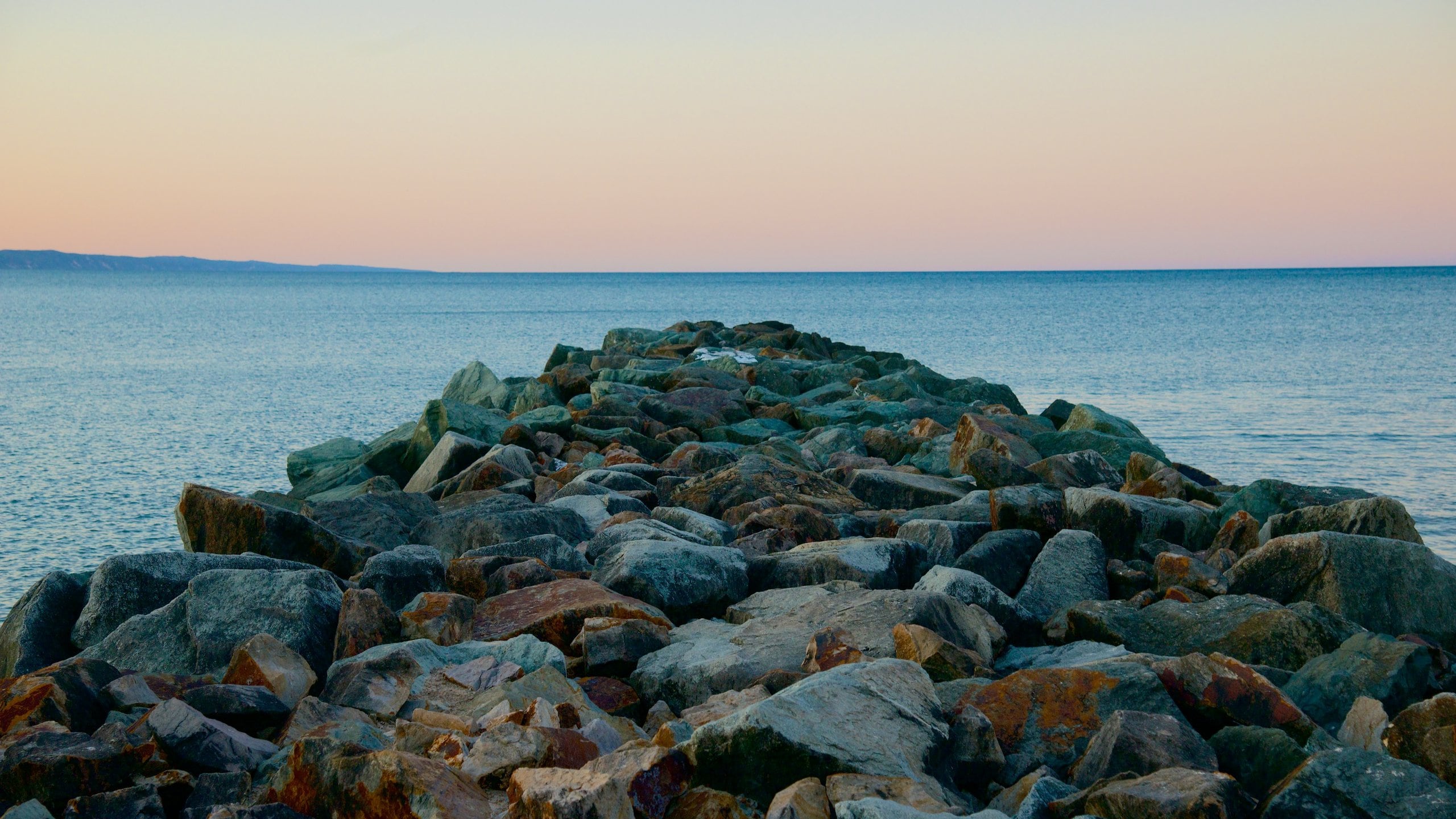 Noosa Beach which includes rocky coastline and a sunset