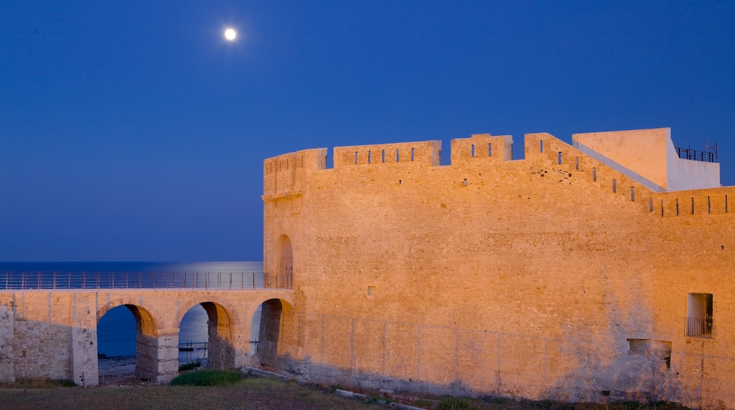 Ortygia que inclui uma cidade litorânea, cenas noturnas e elementos de patrimônio