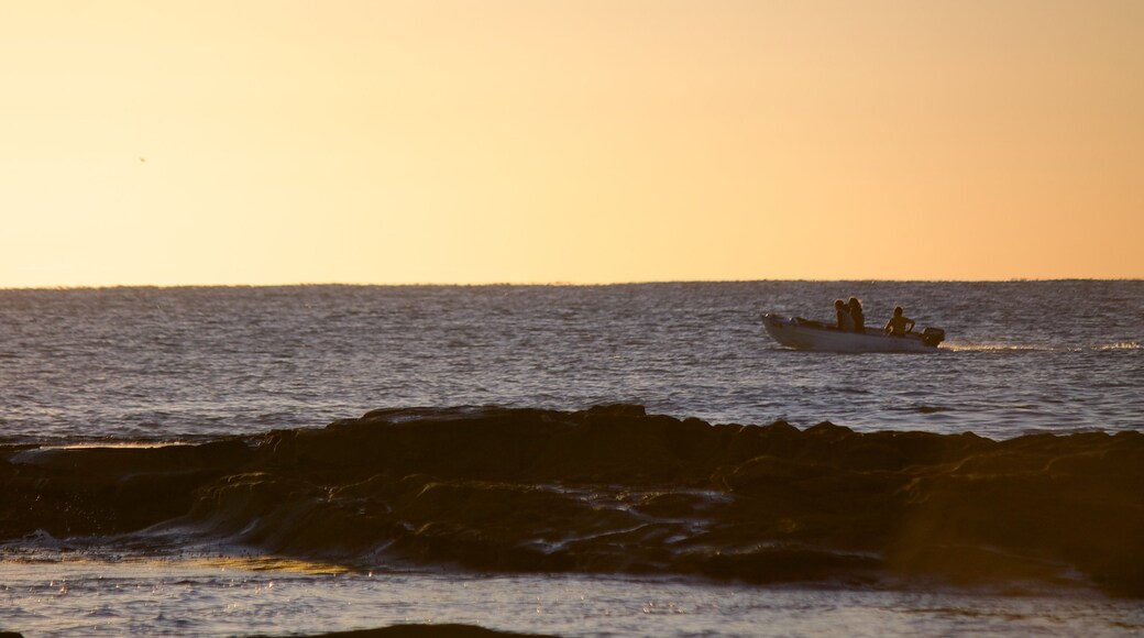 Shelly Beach que incluye vistas de una costa, un atardecer y embarcaciones