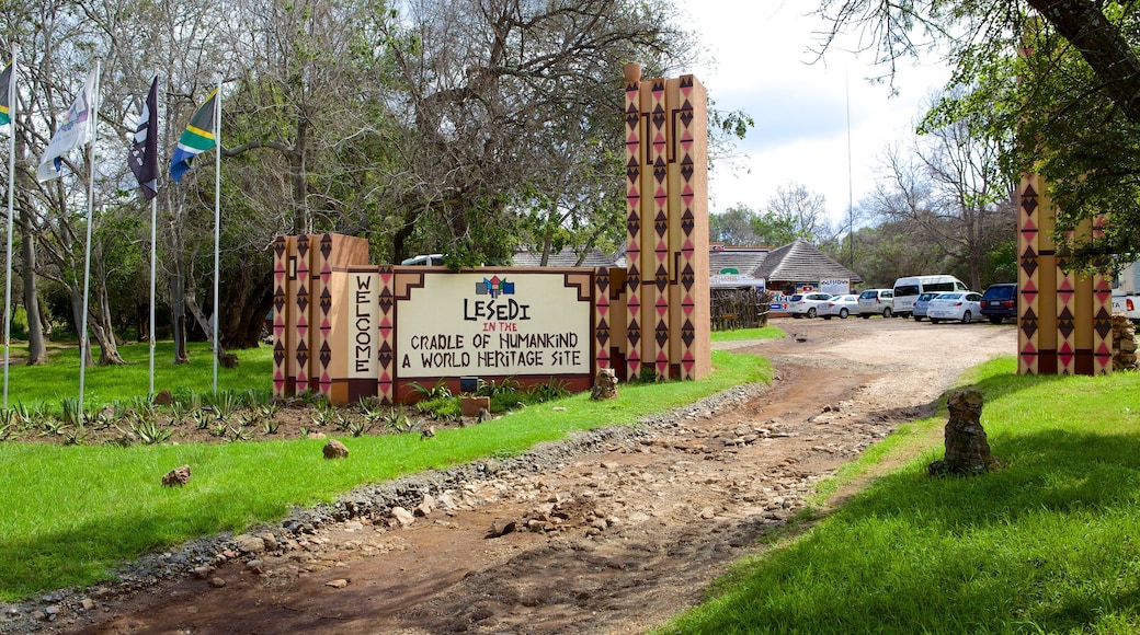 Lesedi Cultural Village que incluye señalización y una pequeña ciudad o pueblo