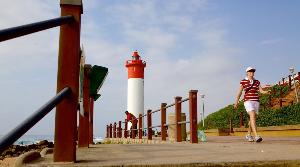 Umhlanga Lighthouse featuring a lighthouse and general coastal views as well as an individual female