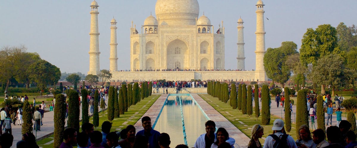 Taj Mahal featuring a temple or place of worship and heritage elements as well as a large group of people