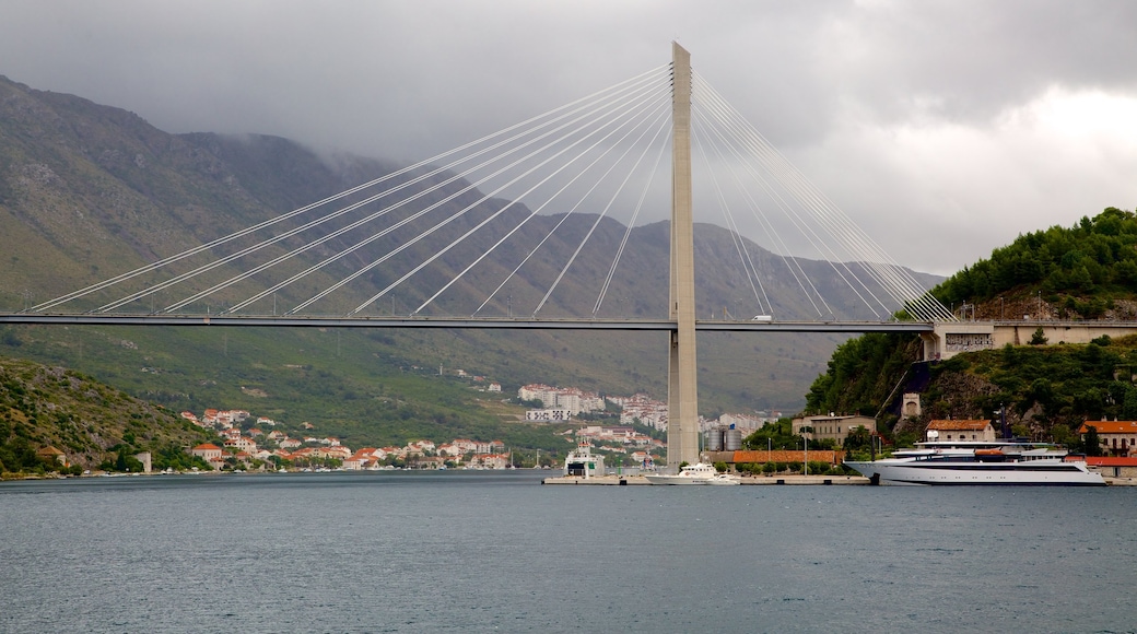 Praia de Lapad que inclui montanhas, uma ponte e um lago ou charco