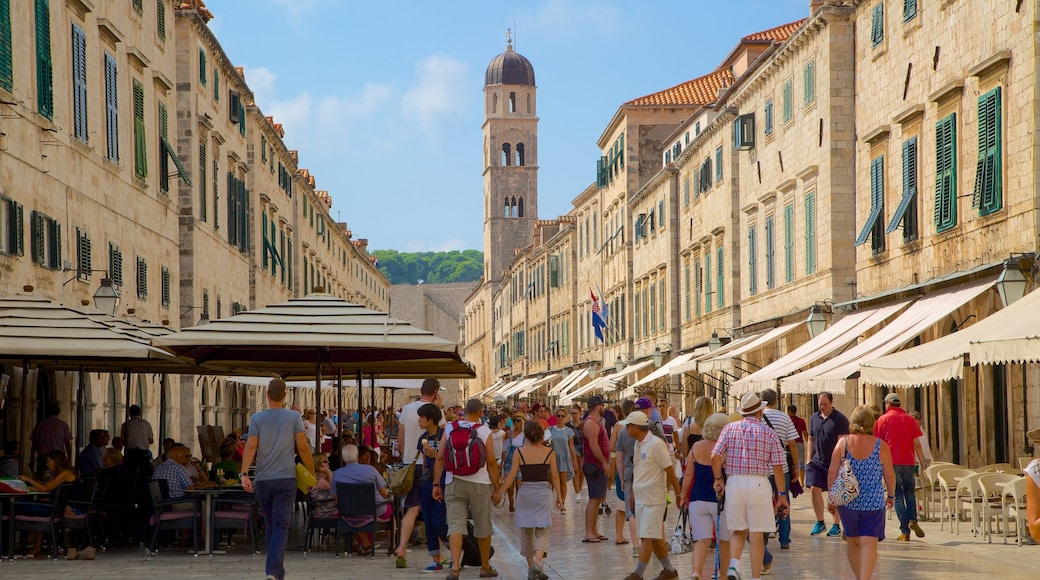 Stradun som inkluderar historisk arkitektur och al fresco-restauranger såväl som en stor grupp av människor