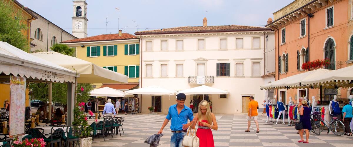 Lazise ofreciendo una ciudad y un parque o plaza y también una pareja