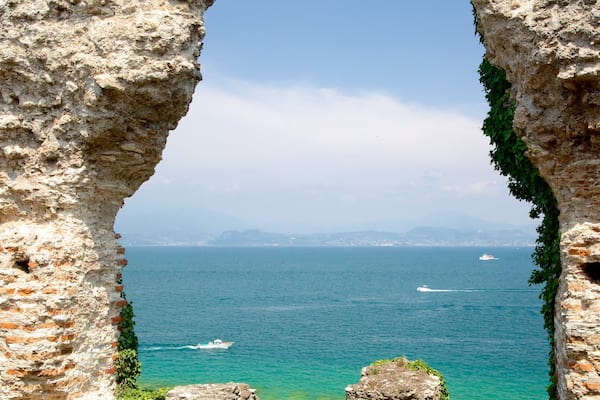 Grotte de Catulle mettant en vedette lac ou étang, bâtiments en ruines et patrimoine historique