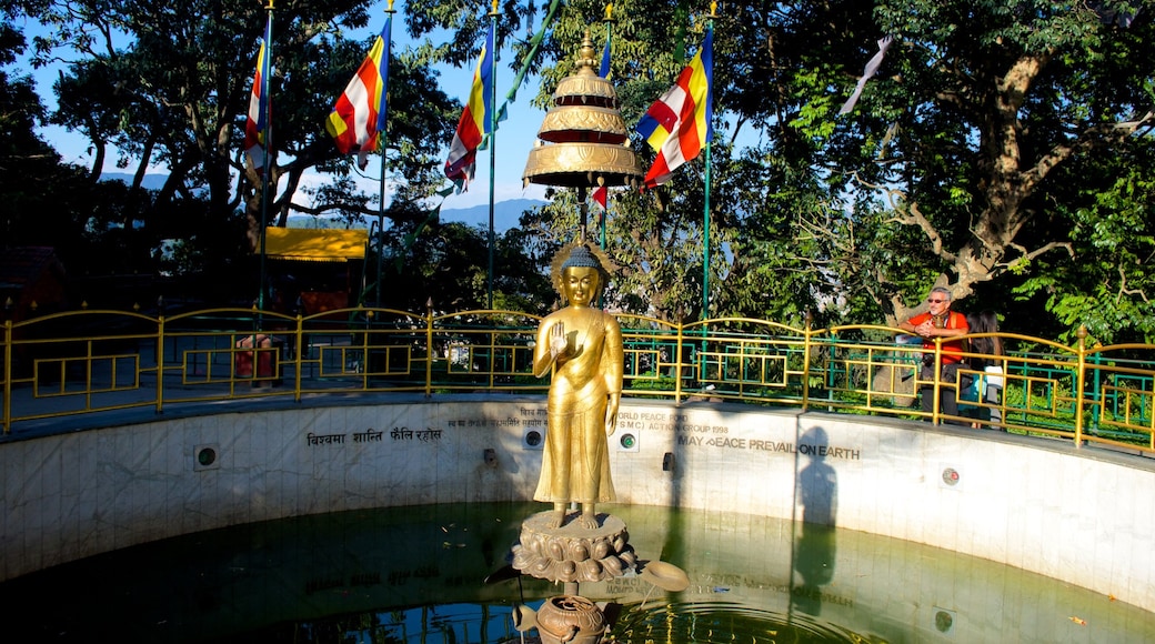 Swayambhunath which includes a pond, religious elements and a statue or sculpture