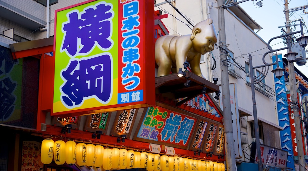 Tsutenkaku Tower featuring signage and a city