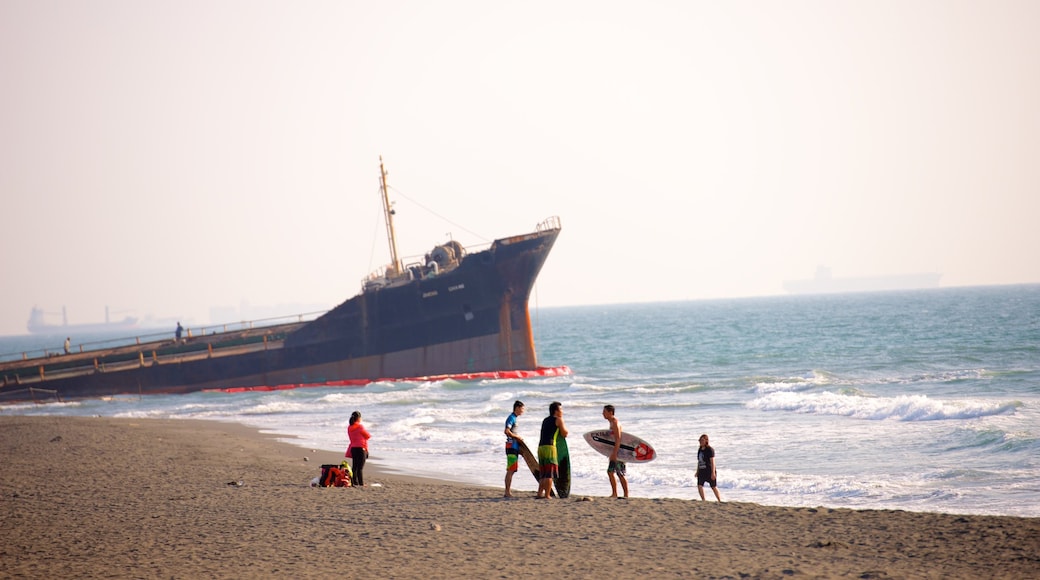 Cijin Seaside Park featuring a sandy beach as well as a small group of people