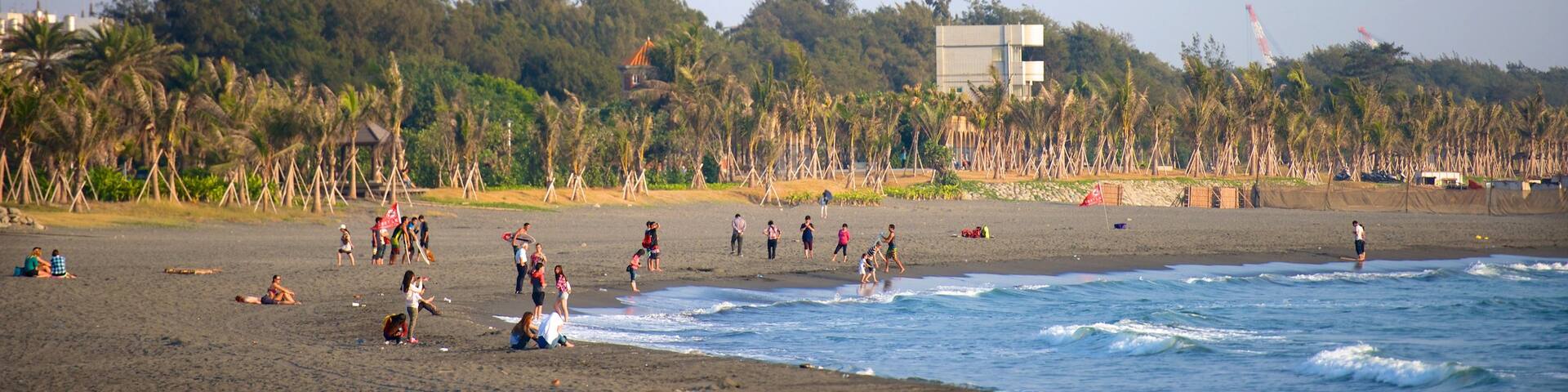 Cijin Seaside Park featuring a sandy beach as well as a small group of people