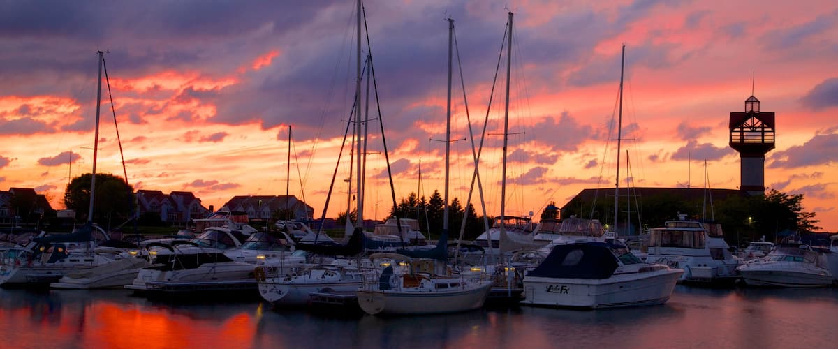 Erie montrant voile, coucher de soleil et baie ou port