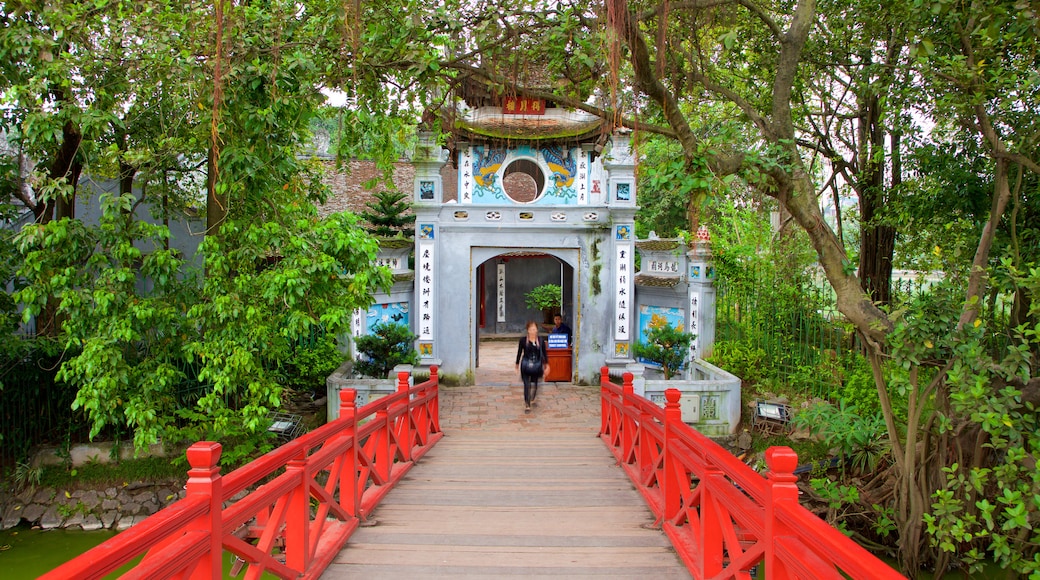 Ngoc Son Temple featuring a bridge as well as an individual femail