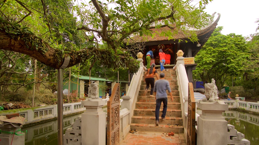 One Pillar Pagoda featuring a temple or place of worship as well as a small group of people