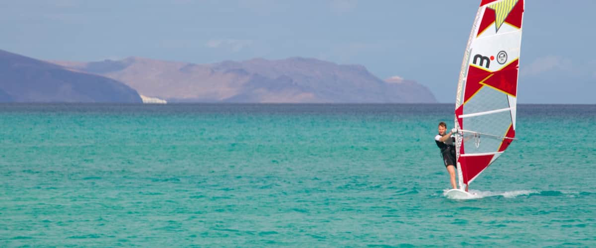 Plage de Sotavento de Jandia mettant en vedette vues littorales et planche à voile aussi bien que homme