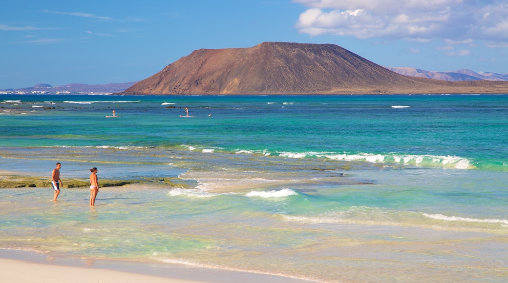 Strand Corralejo bevat algemene kustgezichten, zwemmen en bergen