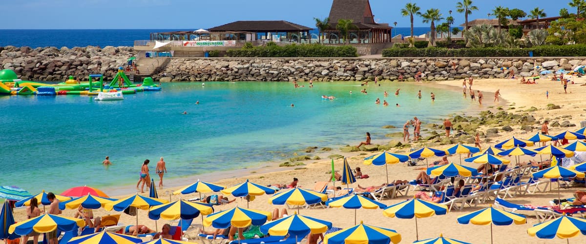 Playa de Amadores que incluye vistas generales de la costa, una playa y un hotel o resort de lujo