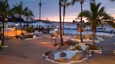 Puerto de la Cruz som viser en solnedgang, et luksushotel eller -resort og en pool