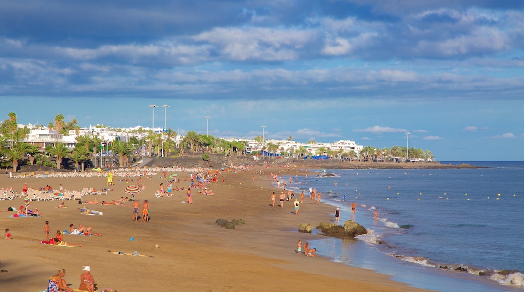 Plage de Puerto del Carmen montrant vues littorales et plage de sable aussi bien que important groupe de personnes