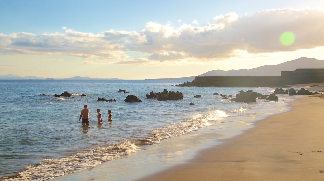 Strand Puerto del Carmen das einen Sonnenuntergang, Schwimmen und allgemeine Küstenansicht