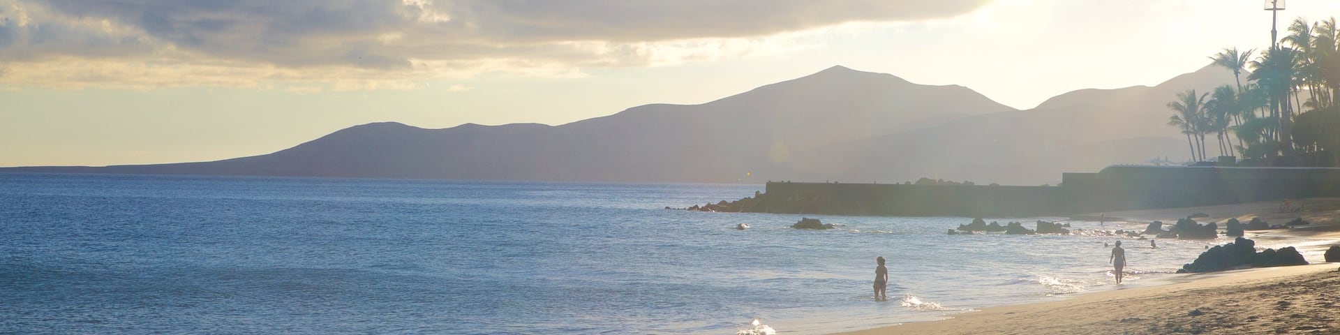 Puerto del Carmen Beach showing a sunset, general coastal views and a beach