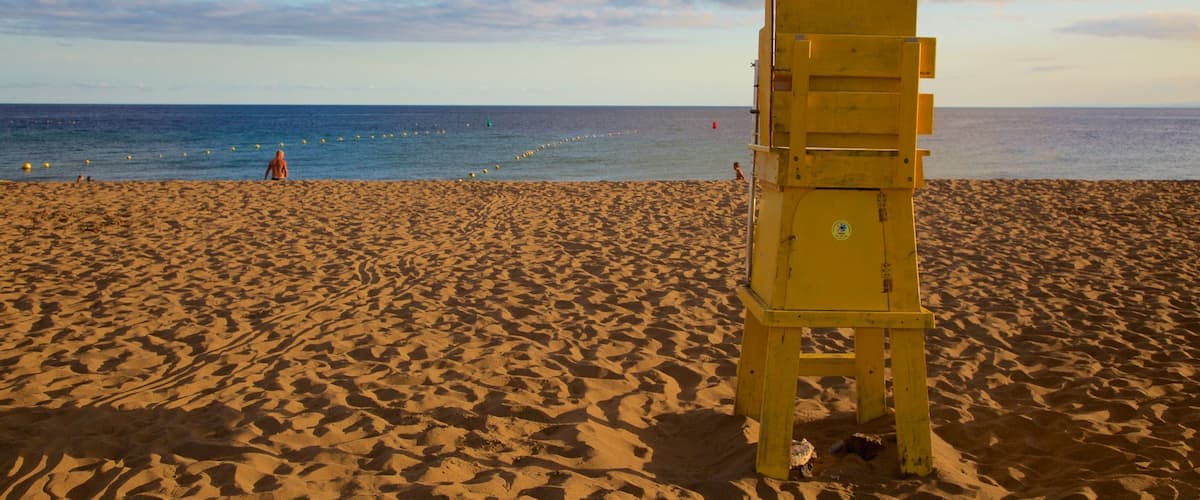 Puerto del Carmen Beach showing a sandy beach, general coastal views and a sunset