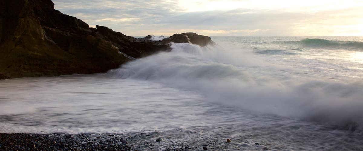 Ajuy Beach showing rugged coastline, a pebble beach and surf
