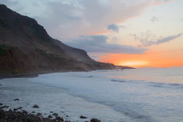 Playa del Scorro das einen Wellen, schroffe Küste und Sonnenuntergang