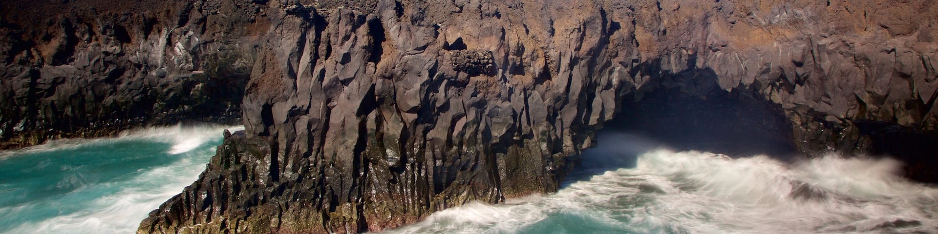Los Hervideros Caves which includes rugged coastline