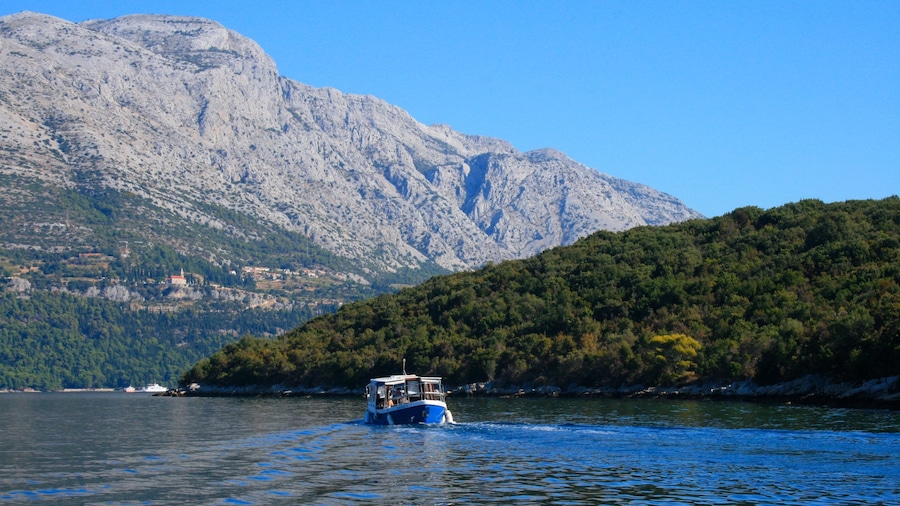 Croacia que incluye un lago o espejo de agua, montañas y botes
