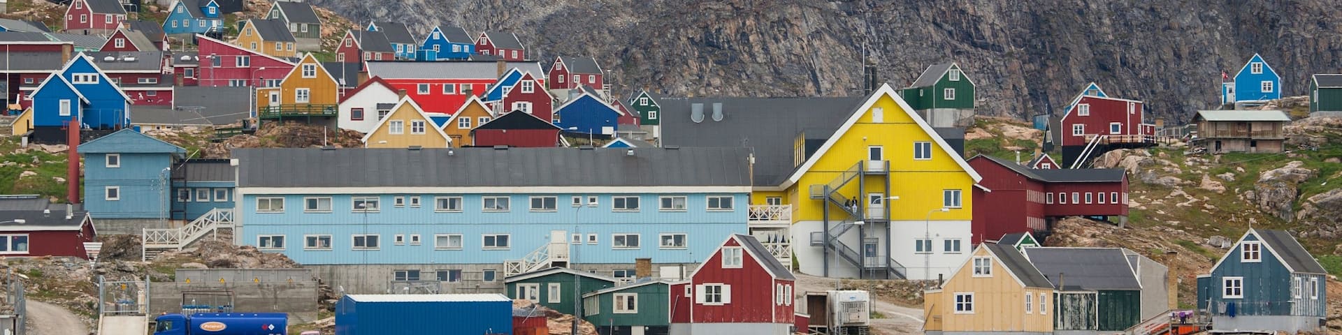 Upernavik showing rocky coastline, mountains and a small town or village