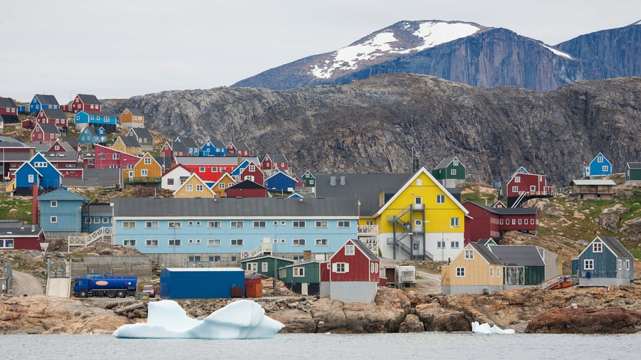 Upernavik som viser barsk kystlinje, en lille by eller en landsby og bjerge