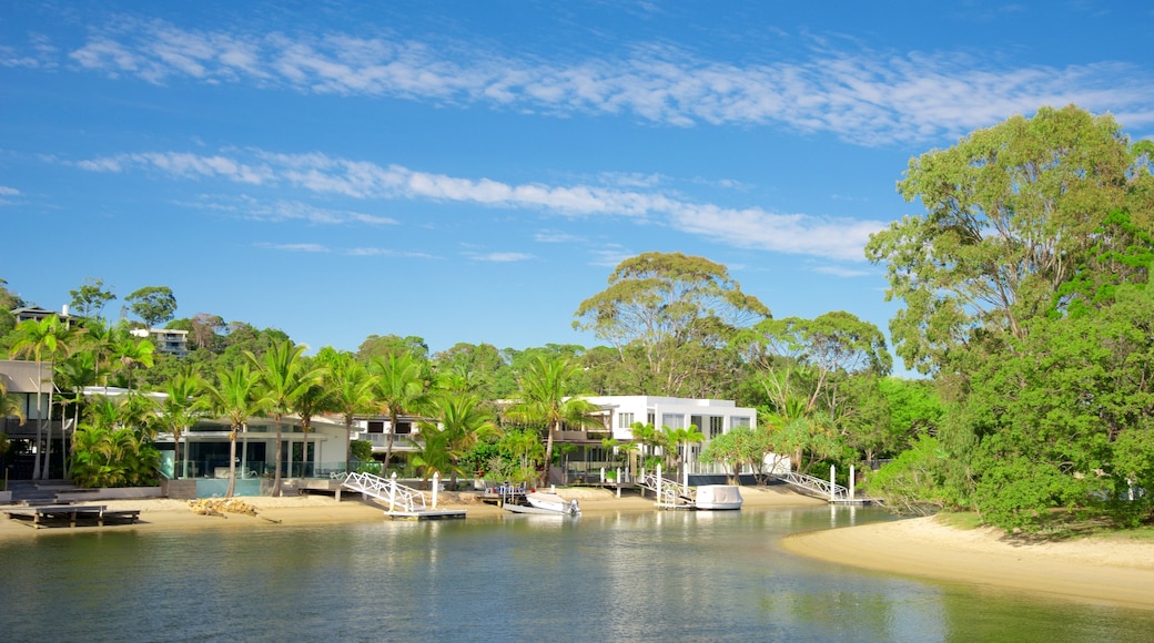 Noosaville que incluye un lago o espejo de agua, una playa y una casa