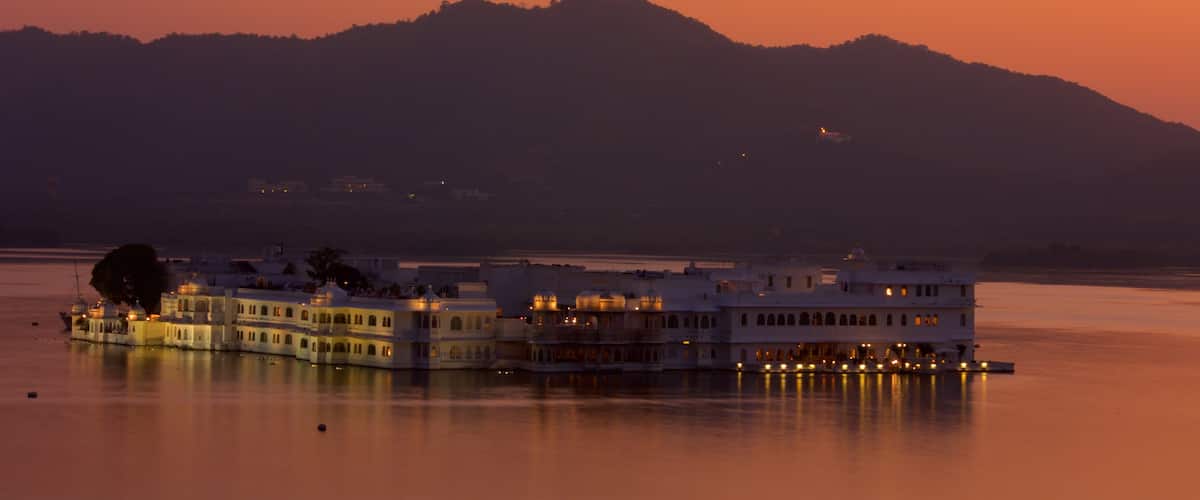 Lake Palace mettant en vedette ville cĂŽtiĂšre, coucher de soleil et vues littorales