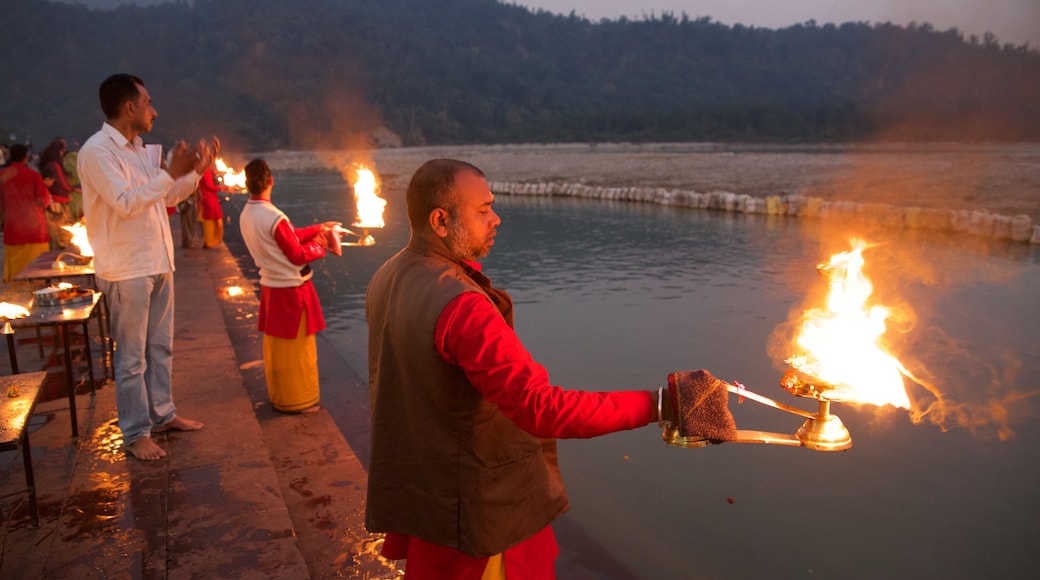 Triveni Ghat mettant en vedette rivière ou ruisseau et aspects religieux aussi bien que petit groupe de personnes