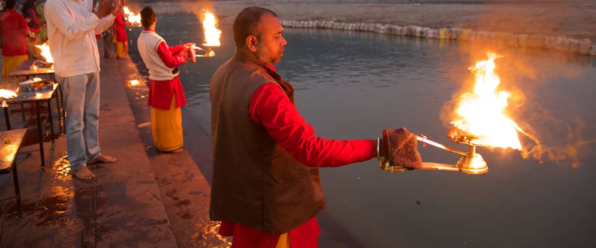 Triveni Ghat mostrando un río o arroyo y aspectos religiosos y también un pequeño grupo de personas