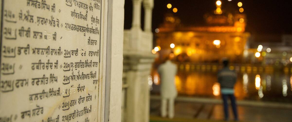 Golden Temple featuring signage and night scenes