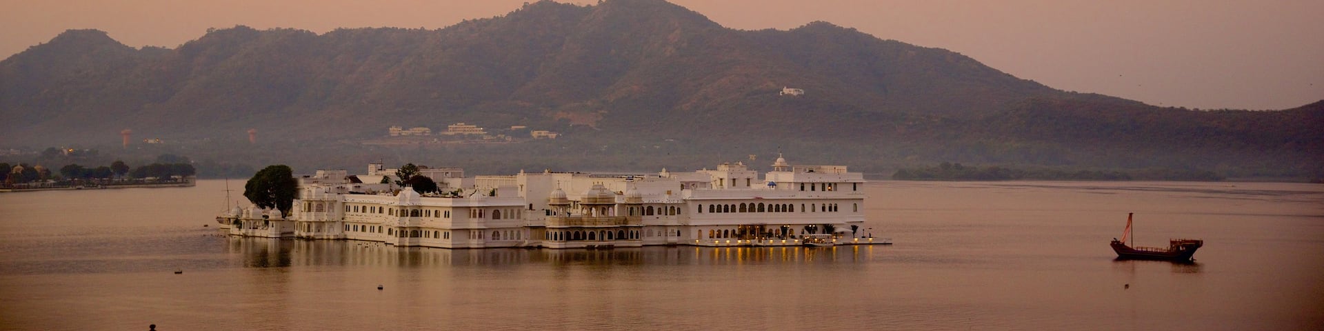 Lake Palace showing a lake or waterhole, island views and a sunset