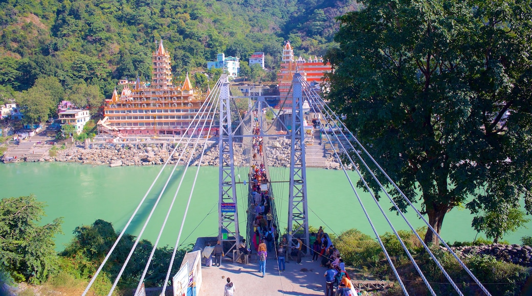 Lakshman Jhula presenterar en hängbro, en liten stad eller by och en å eller flod