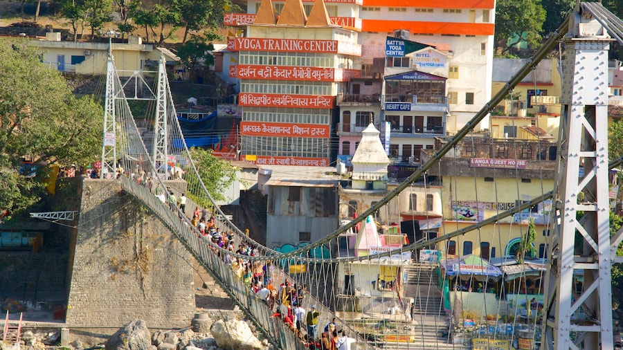 Lakshman Jhula featuring a suspension bridge or treetop walkway and a city as well as a large group of people